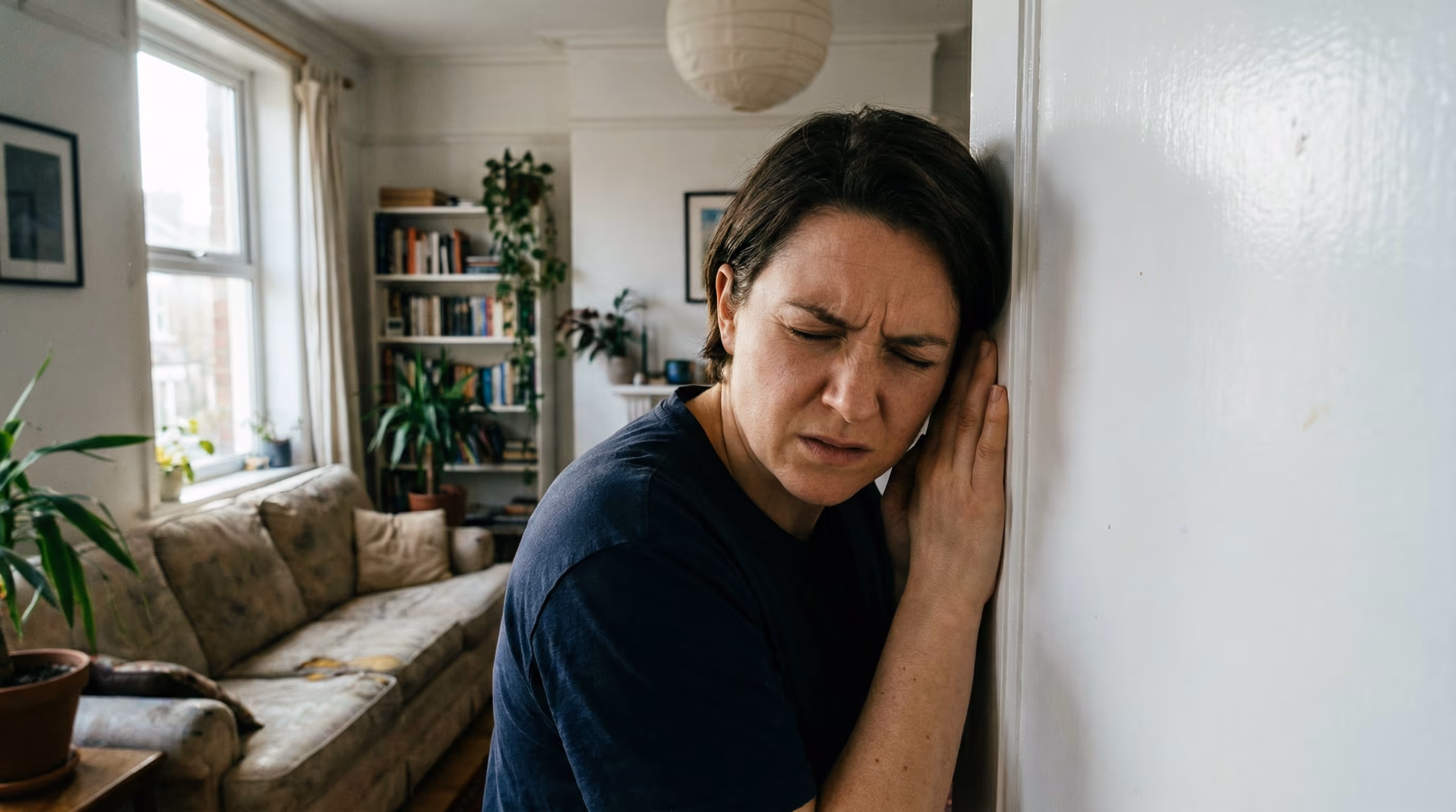 Pessoa ouvindo barulho de água na parede